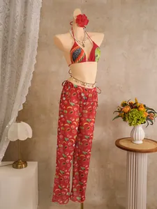 Detail of red bikini top and tropical fruit print wide leg pants on a model