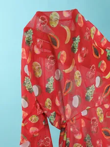 Detail of red mesh fabric with tropical fruit digital print and semi-transparent texture