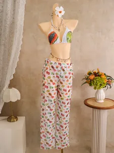 Detail of tropical fruit print bikini top and sheer wide-leg pants on a mannequin