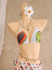 Close-up of tropical fruit print bikini with decorative shell necklace and starfish belt