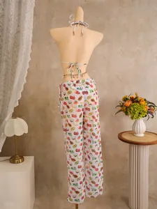 Rear view of tropical fruit print high-waisted sheer pants and bikini set with waist chain
