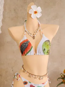 Close-up of tropical fruit print on halter bikini with papaya and lime patterns