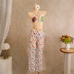Detailed view of bikini top and sheer wide-leg pants with tropical fruit patterns