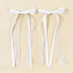 Detail of white lace bow hair clips with long elegant ribbons for ballet style hair