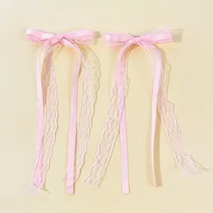 Detail of pink ballet-style lace ribbon hair clips with satin textures and long tassels