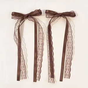 Detailed close-up of dark brown double-layered lace bow clips with elegant long ribbons