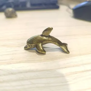 Close-up of vintage bronze dolphin figurine showing detailed texture and metallic finish