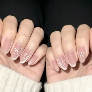Détail de faux ongles amande oeil de chat rose avec motifs de nœuds et cœurs