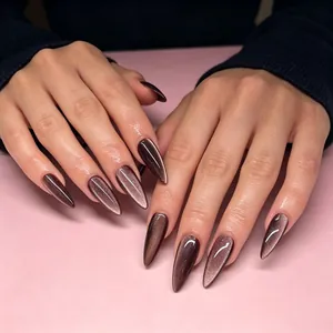 Détail de faux ongles amande longs avec effet œil de chat en marron brillant