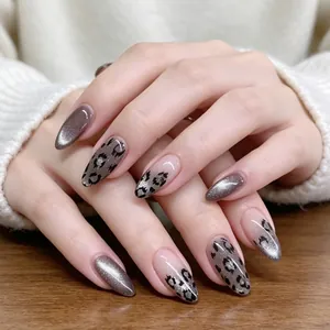 Détail de faux ongles en amande avec motif léopard et effet oeil de chat argenté