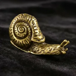 Dettagli macro di una statuina di lumaca in bronzo massiccio con texture a spirale