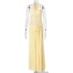 Détail de la robe en maille jaune clair avec licou et tissu transparent plissé