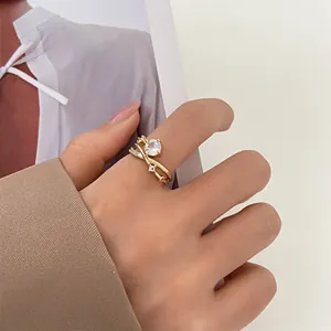 Close-up of golden crisscross ring with large round zircon worn on female hand