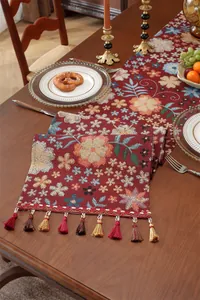 Nahaufnahme eines Vintage-Jacquard-Tischläufers mit dekorativen Fransen und Quasten
