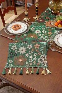 Nahaufnahme des grünen Jacquard-Tischläufers mit Blumenmustern und Quasten