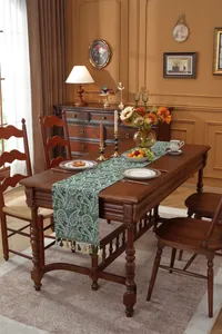 Detailaufnahme des grünen Tischläufers mit Paisleymuster und eleganten Quasten