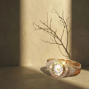 Detail of gold quartz bracelet watch with sparkling crystals and spiral metal band