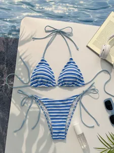 Piatto di bikini a righe bianche e blu in spugna con sfondo piscina e vacanza