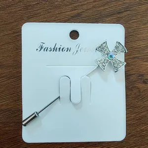 Nahaufnahme der silbernen Kreuzbrosche mit Kristallen und Sicherheitsverschluss