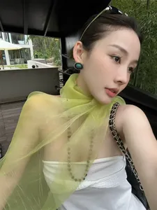 Detail of light green sheer scarf with gold silk texture and translucent finish