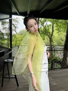 Detail of sheer bright yellow lightweight silk scarf with elegant semi-transparent texture