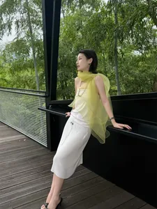 Close-up of translucent light yellow faux silk scarf styled with a white dress