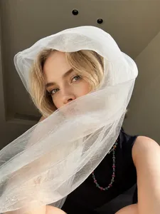 Close-up of lightweight off-white sheer silk scarf with soft mesh texture for women