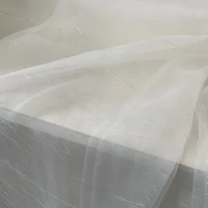 Detail of white sheer silk scarf featuring shimmering silver wave texture patterns
