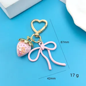 Pink strawberry heart-shaped gold keychain with bow pendant, height 87mm width 42mm
