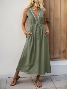 Detail of V-neck sage green dress with delicate lace trim and fabric buttons