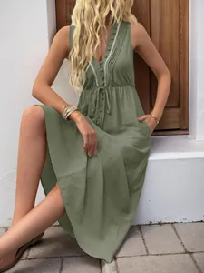 Detail of sage green V-neck dress featuring buttons, drawstring waist and side pockets