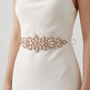Detail of rose gold bridal belt with sparkling rhinestones and white pearls on ribbon