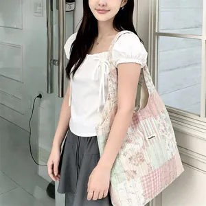Dettaglio della borsa tote patchwork floreale con cuciture trapuntate ed etichetta