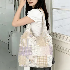 Primo piano del tessuto patchwork floreale trapuntato e dell'etichetta sulla borsa tote