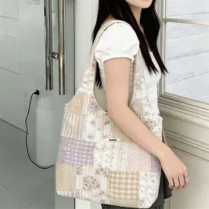 Dettaglio della borsa tote patchwork floreale con etichetta del marchio tessuta