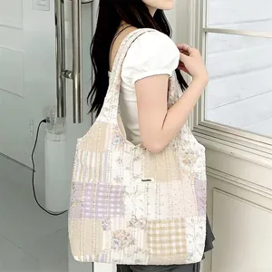 Vista dettagliata della borsa tote patchwork trapuntata con motivi floreali