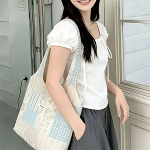 Dettaglio della borsa tote patchwork a fiori con strisce blu ed etichetta