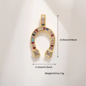 Macro detail of gold horseshoe charm with multi-colored cubic zirconia and dimensions