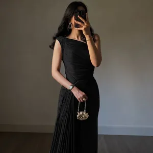 Detail of elegant black one shoulder ruched evening gown with pleated texture