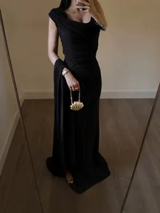 Elegant black ruched one-shoulder evening gown with shell clutch and floor-length design