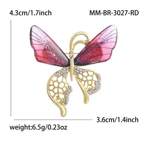 Élégante broche papillon dorée avec ailes violettes et cristaux blancs brillants