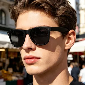 Close-up of man wearing square polarized sunglasses with matte black frames outdoors