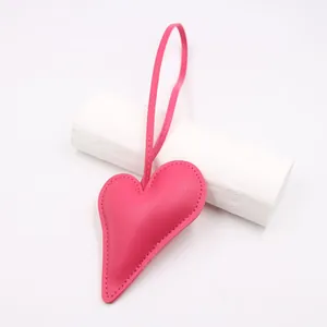 Detail of pink faux leather heart charm with lychee texture and matching stitching
