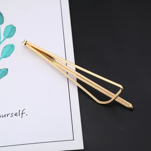 Detail shot of a minimalist gold geometric metal hair clip on an illustrative card