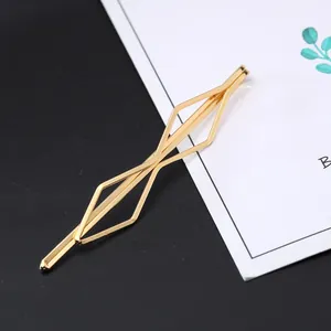 Macro detail of golden geometric hair clip with hollow rhombus metal structure