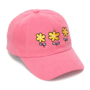 Close-up of pink baseball cap featuring detailed yellow flower embroidery and texture