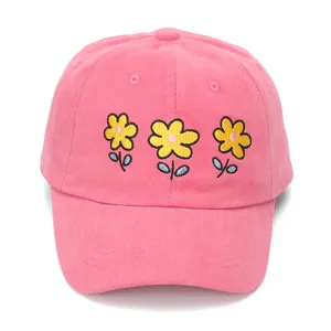 Close-up of pink cotton baseball cap featuring three yellow daisy floral embroideries