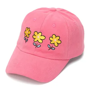 Close-up of pink baseball cap featuring detailed yellow flower embroidery and cotton texture
