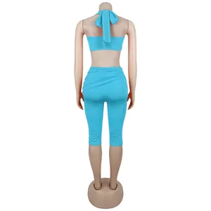 Back view of turquoise halter crop top with tie-up detail and matching slim leggings