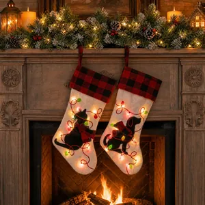 Lighted Christmas stockings with cat and dog designs hanging on a festive fireplace